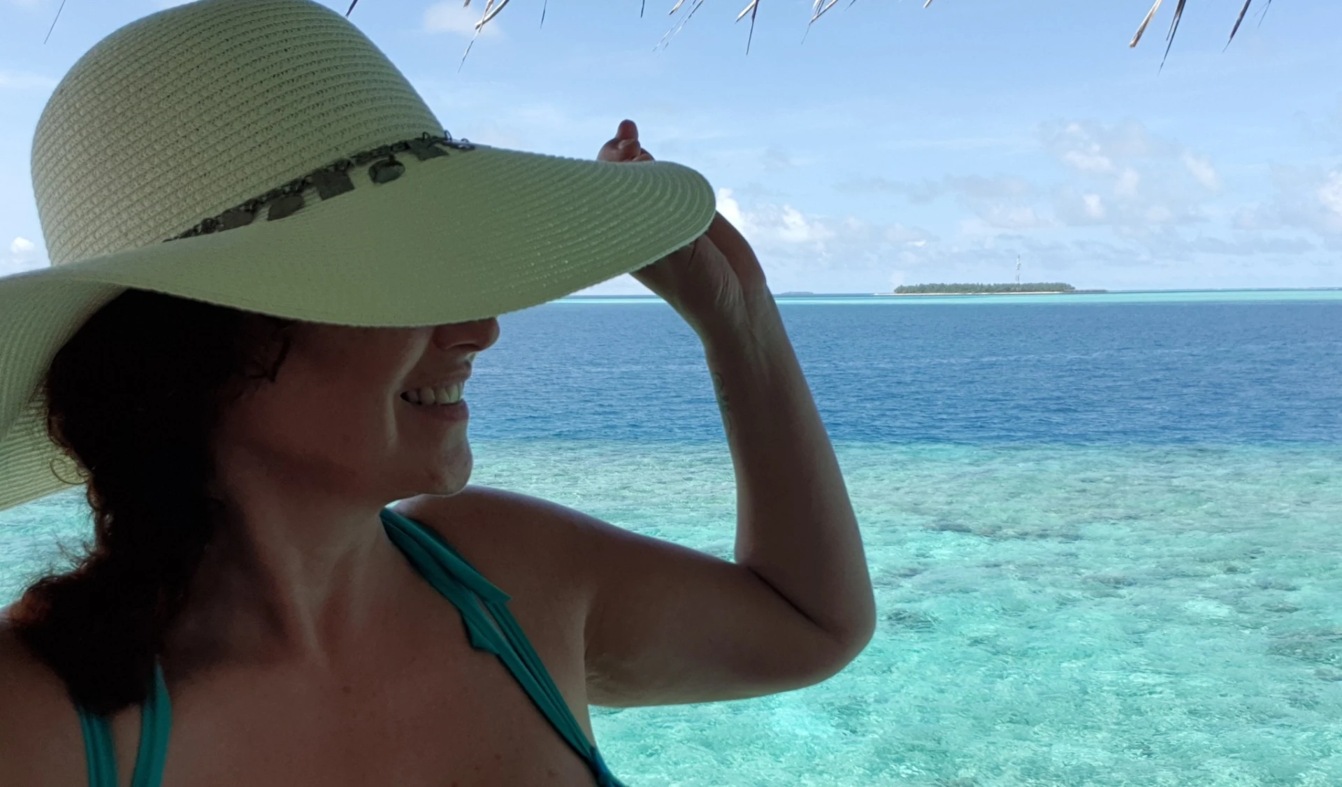 vrouw met hoed en oceaan