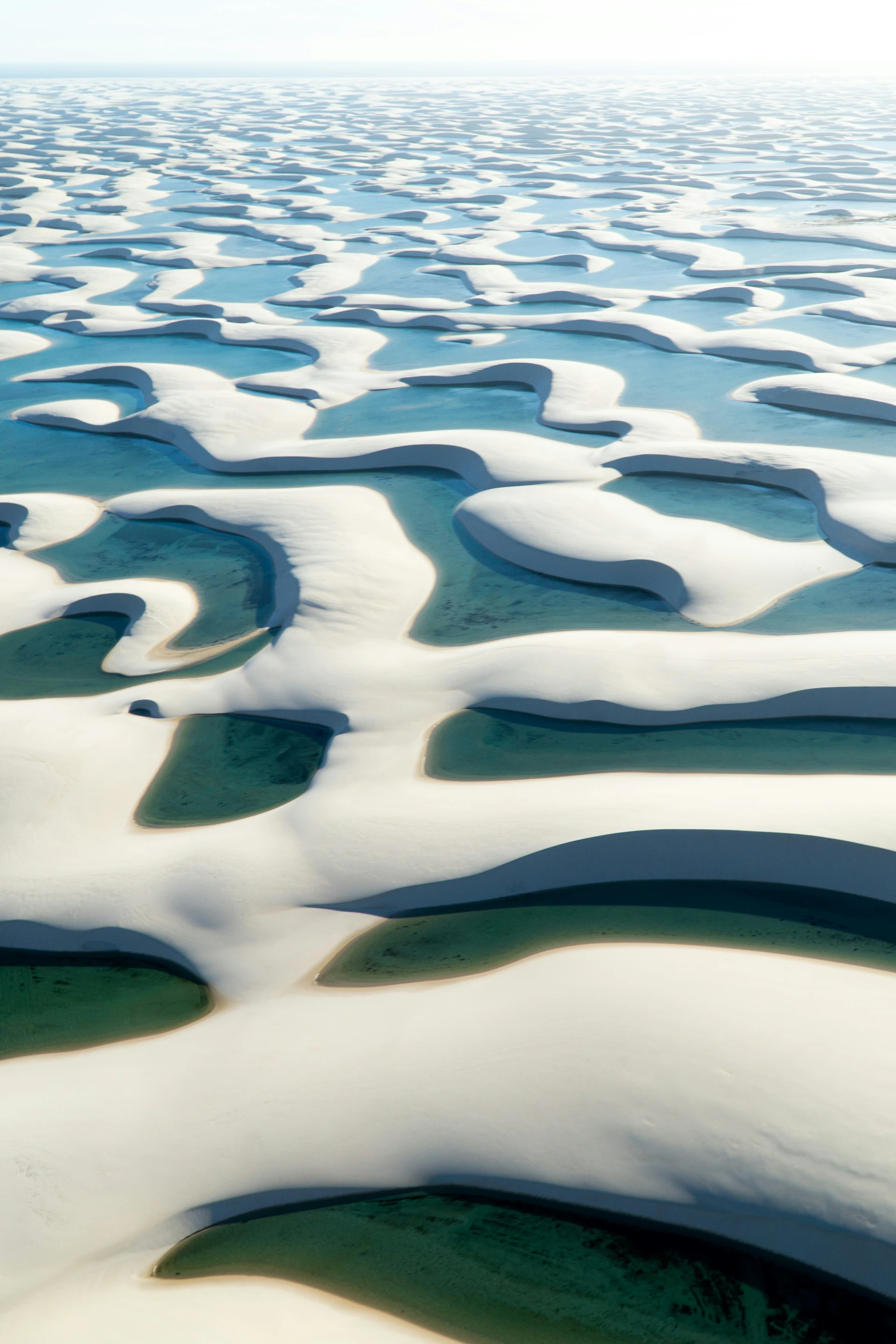witten zandduinen en blauw water
